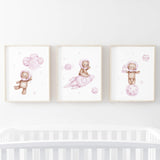 Set of 3 watercolor astronaut teddy bear in space poster in pink and brown colors for baby girls room decor.